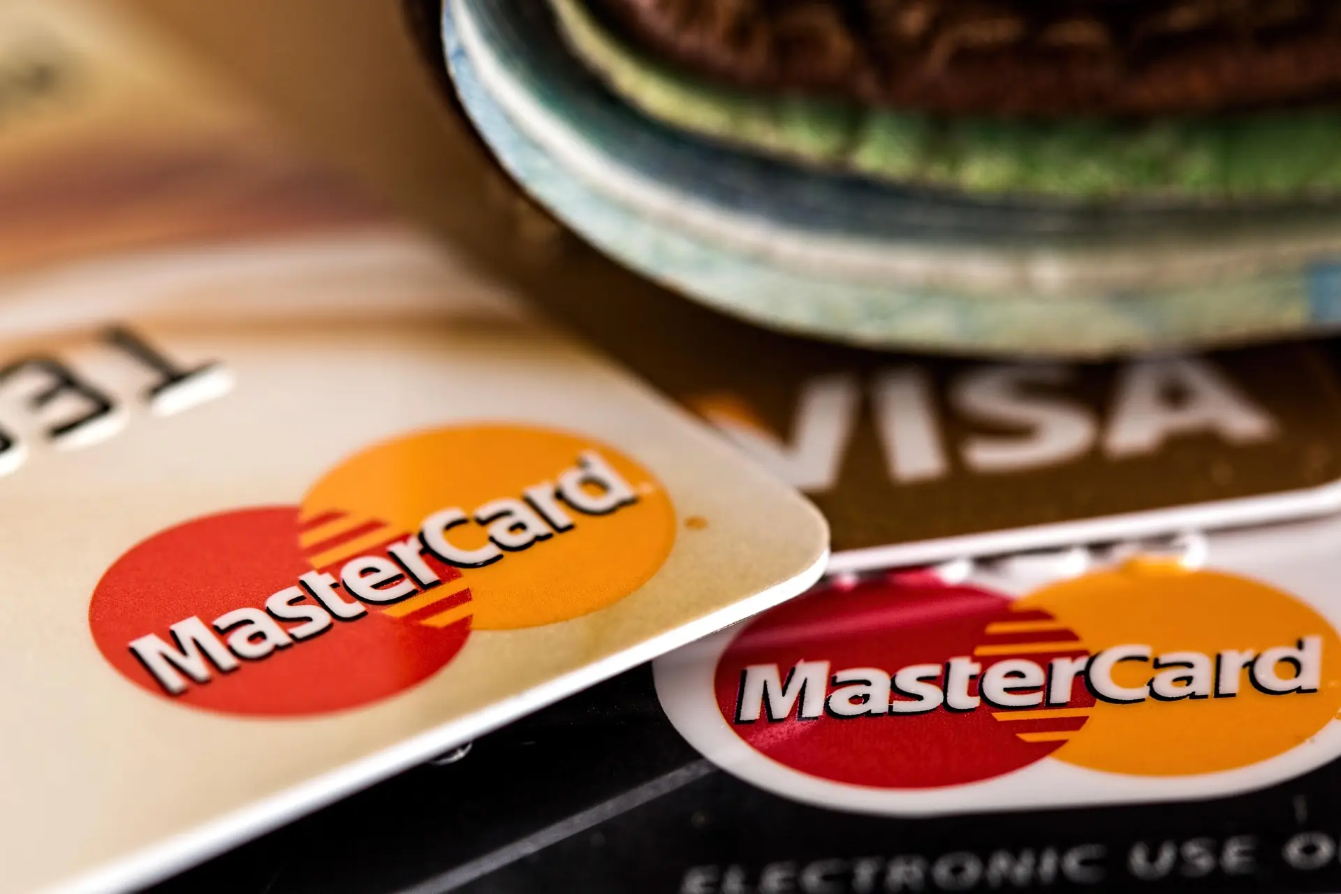 Several Mastercard and Visa credit cards stacked on top of each other – cards like these can buy crypto online, at a premium