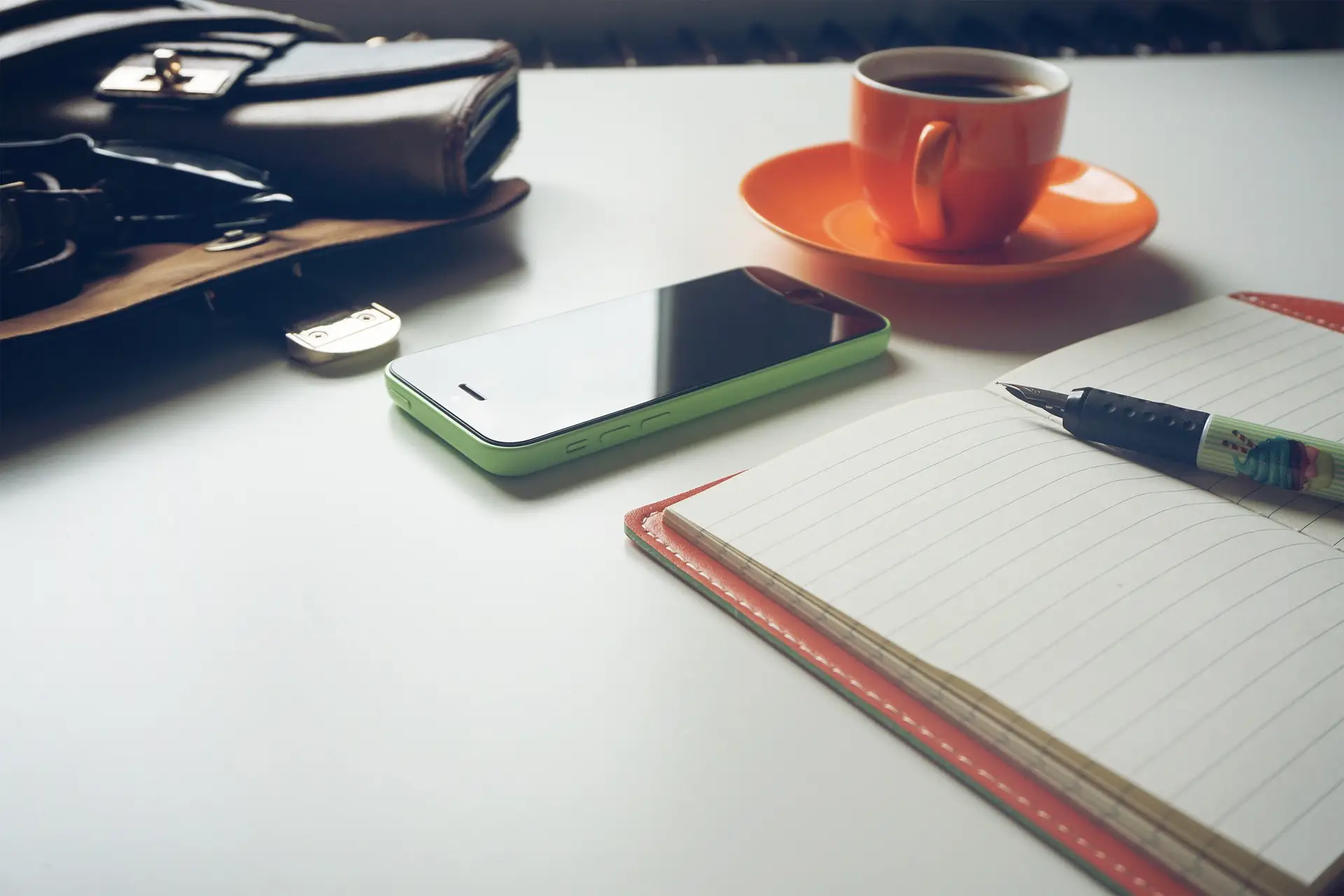Smartphone, Notizbuch und Kaffee auf dem Schreibtisch