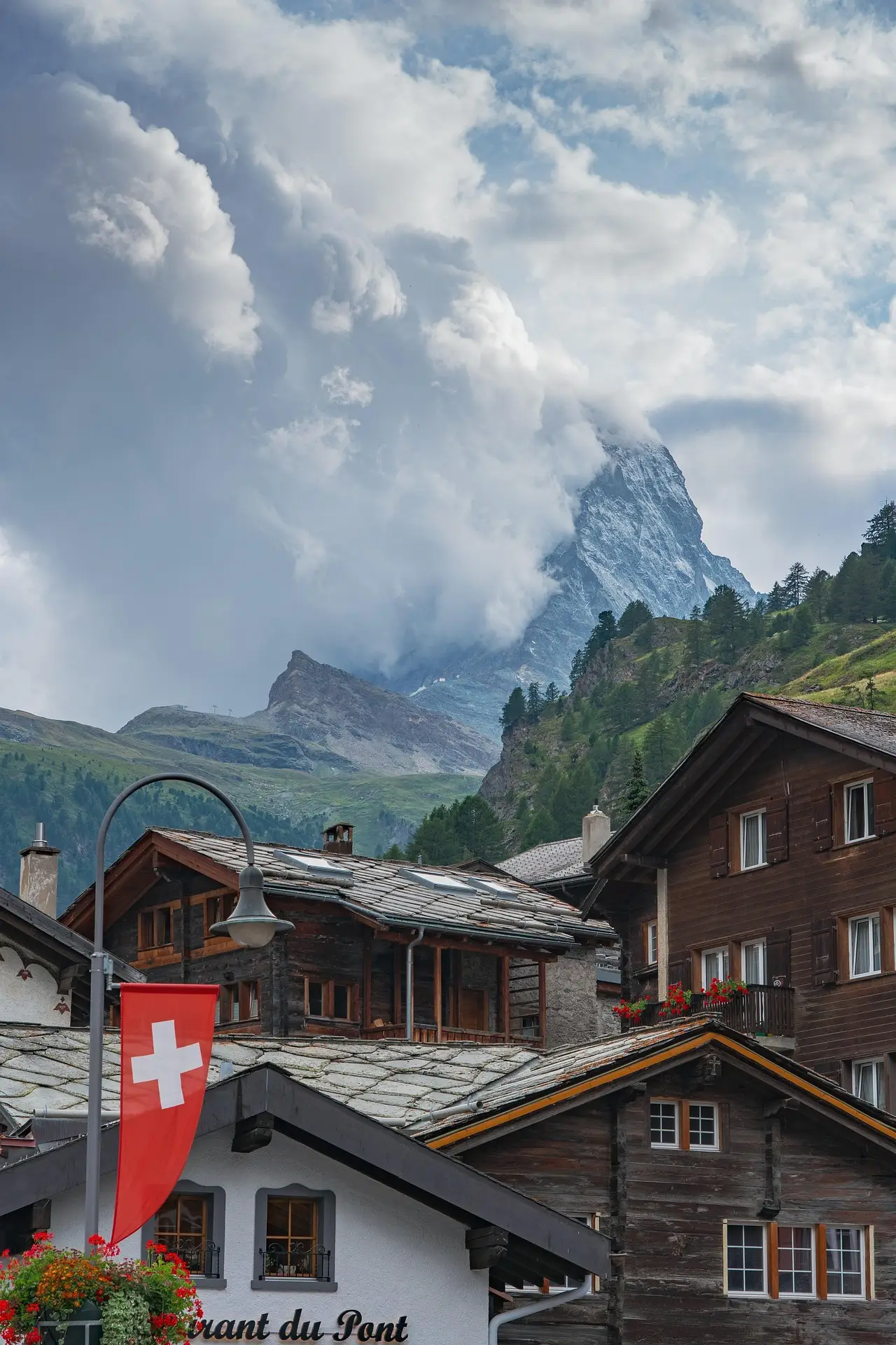 Chalets in Zermatt mit Schweizer Flagge und Matterhorn